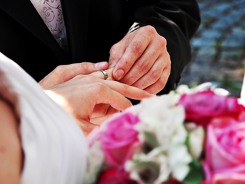 Groom-putting-wedding-band-on-brides-ring-finger